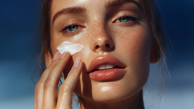 Woman pressing Ayurvedic recovery cream into her cheek, skin calm and glowing — VediKure Recovery collection